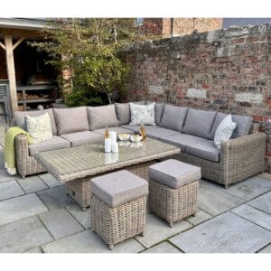 The modular corner seating arrangement provides ample space for family and guests, while the adjustable riser table effortlessly transitions between a casual coffee table and a dining-height table, making it perfect for al fresco dining or lounging. The addition of two matching stools ensures extra seating without compromising on style.